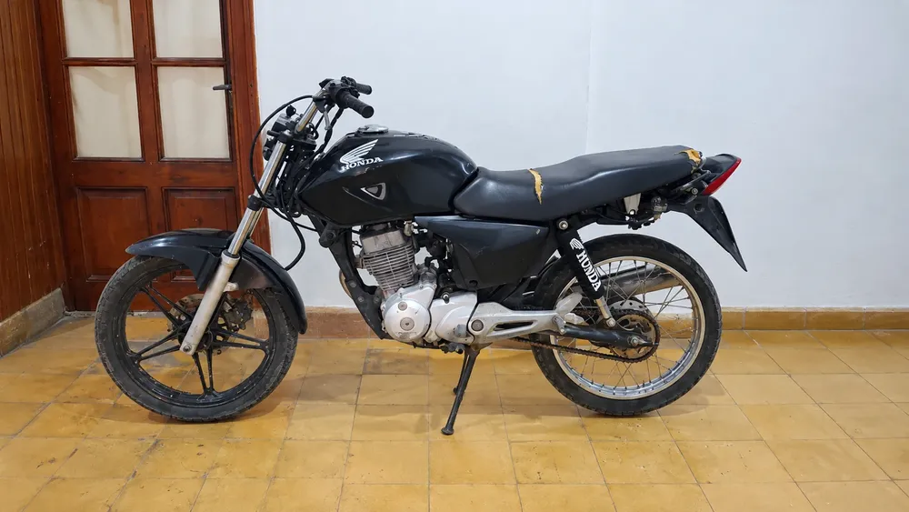 Motocicleta Honda negra en garaje tiled